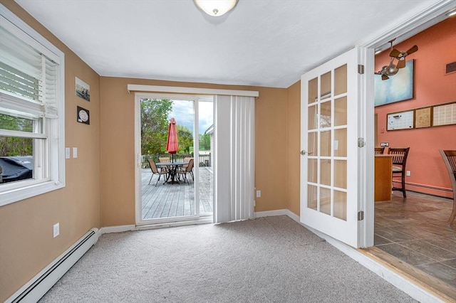unfurnished room with a baseboard radiator, baseboards, and french doors