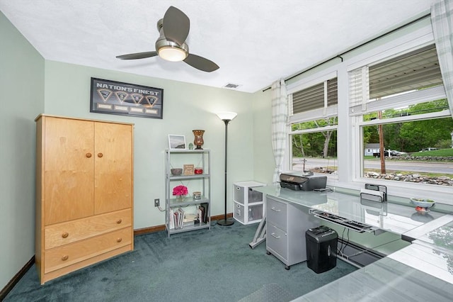 office area featuring dark colored carpet, baseboards, and a ceiling fan