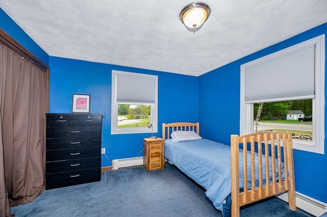 carpeted bedroom featuring baseboard heating, baseboards, and a textured ceiling
