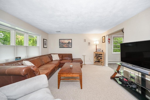 carpeted living area featuring baseboards