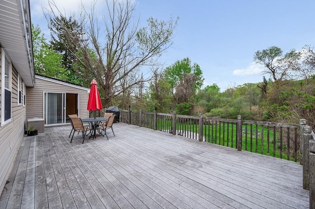 wooden deck featuring outdoor dining space and a grill