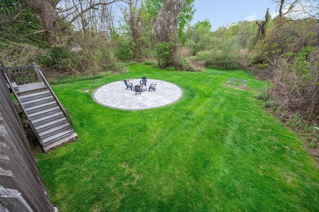 view of grassy yard with a patio area, stairs, and an outdoor fire pit