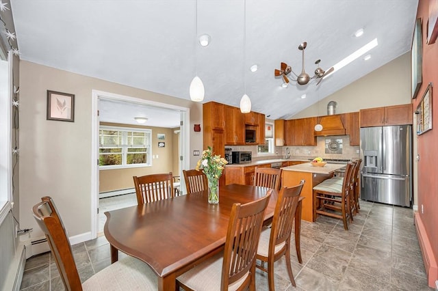 dining area featuring a baseboard heating unit, vaulted ceiling, baseboards, a skylight, and light stone finish flooring