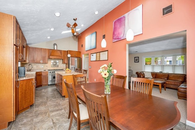 dining space featuring high vaulted ceiling and recessed lighting