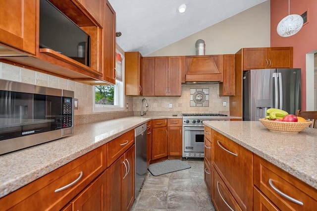 kitchen featuring appliances with stainless steel finishes, vaulted ceiling, a sink, tasteful backsplash, and custom exhaust hood