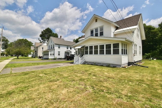 176 N Blvd, West Springfield, MA 01089 - view of front of home with a sunroom, roof with shingles, and a front lawn