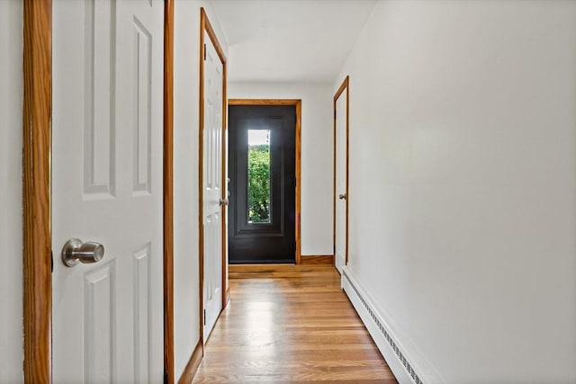 entryway with light wood finished floors, baseboards, and a baseboard radiator