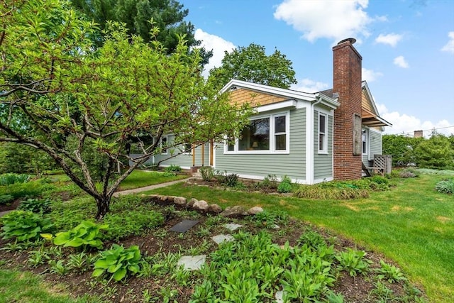 view of home's exterior featuring a chimney and a lawn