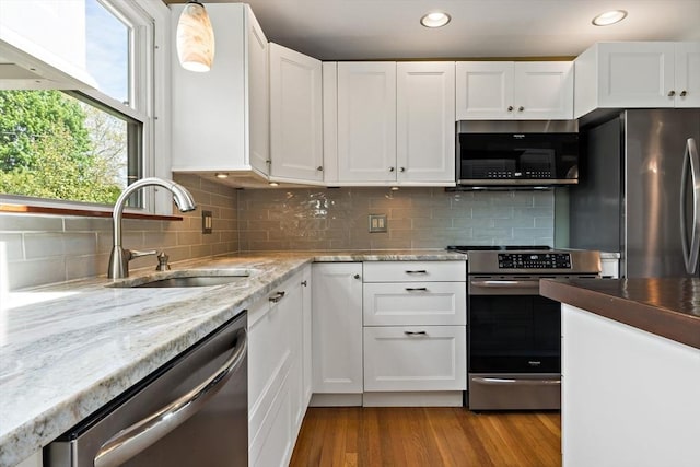 kitchen with stainless steel appliances, a sink, white cabinetry, and recessed lighting
