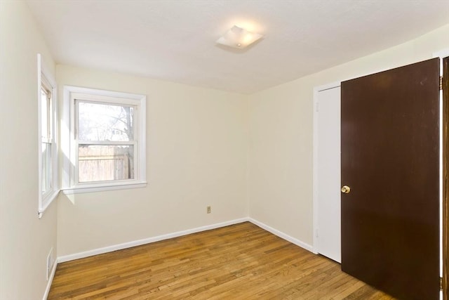 empty room with light wood-style floors and baseboards