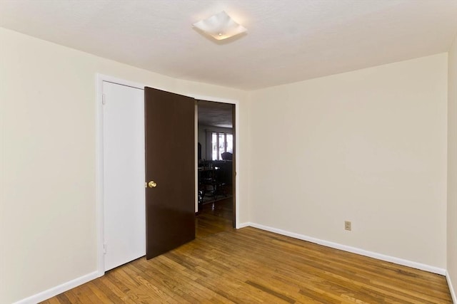 empty room featuring light wood-style flooring and baseboards