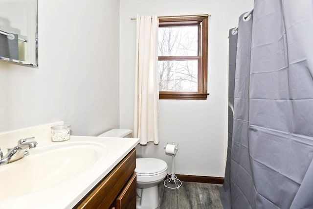 bathroom featuring baseboards, toilet, a shower with curtain, wood finished floors, and vanity