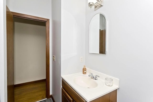 bathroom featuring wood finished floors, vanity, and baseboards