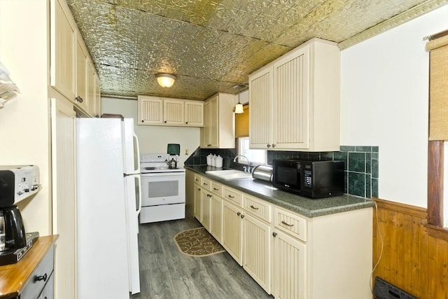 kitchen featuring an ornate ceiling, dark wood-style floors, a wainscoted wall, a sink, and white appliances