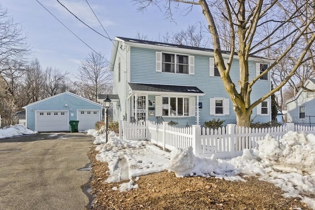 view of front of house with a garage, an outdoor structure, and a fenced front yard