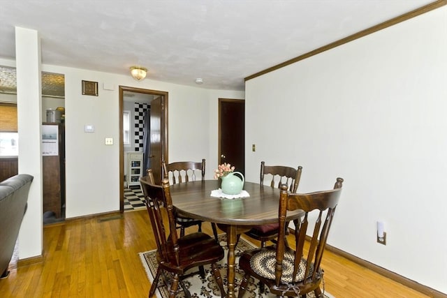 dining area with light wood-style floors and baseboards