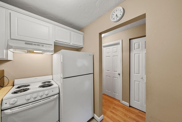 kitchen with under cabinet range hood, white appliances, white cabinets, light wood finished floors, and baseboards