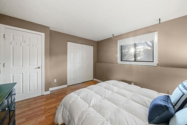 bedroom featuring a closet, baseboards, and wood finished floors