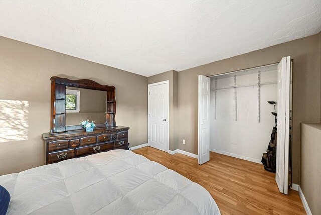 bedroom with baseboards and wood finished floors