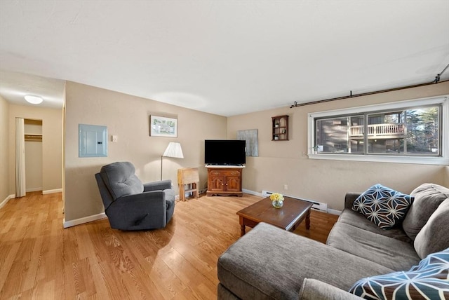 living room with a baseboard heating unit, electric panel, baseboards, and light wood-type flooring