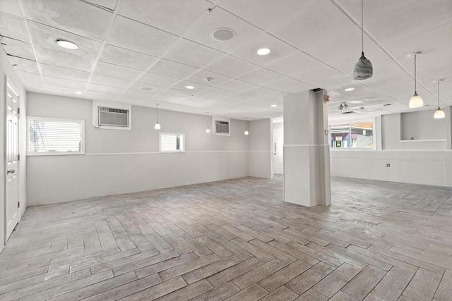 basement with a wall unit AC, plenty of natural light, and recessed lighting
