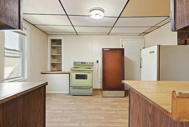kitchen featuring white appliances, light wood-type flooring, and a drop ceiling