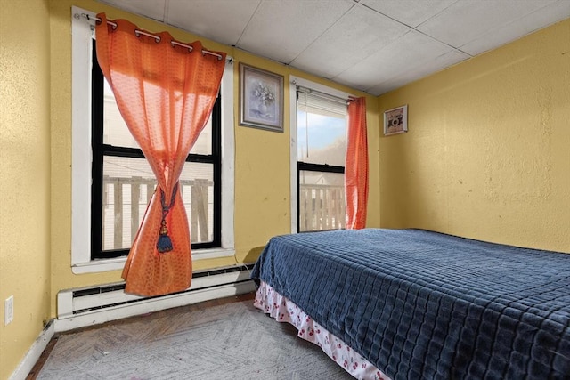bedroom featuring a baseboard heating unit and baseboards