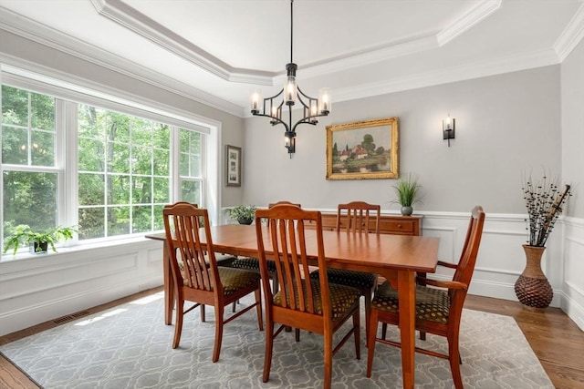 16 Winfield St, Needham, MA 02492 - dining space featuring wood finished floors, a chandelier, crown molding, a raised ceiling, and a wainscoted wall