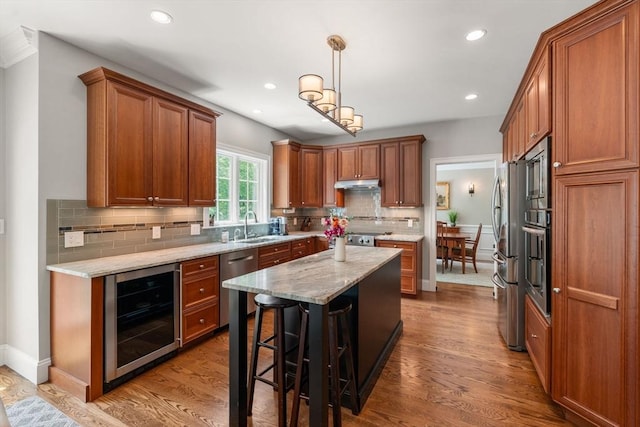 16 Winfield St, Needham, MA 02492 - kitchen with beverage cooler, stainless steel appliances, under cabinet range hood, brown cabinetry, and recessed lighting