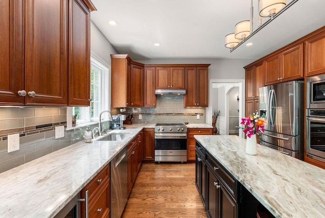 16 Winfield St, Needham, MA 02492 - kitchen featuring appliances with stainless steel finishes, light stone counters, backsplash, light wood-type flooring, and recessed lighting