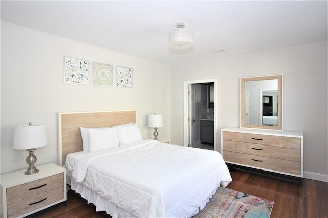318 Concord Ave Unit 1, Cambridge, MA 02138 - bedroom with dark wood-type flooring, baseboards, and connected bathroom