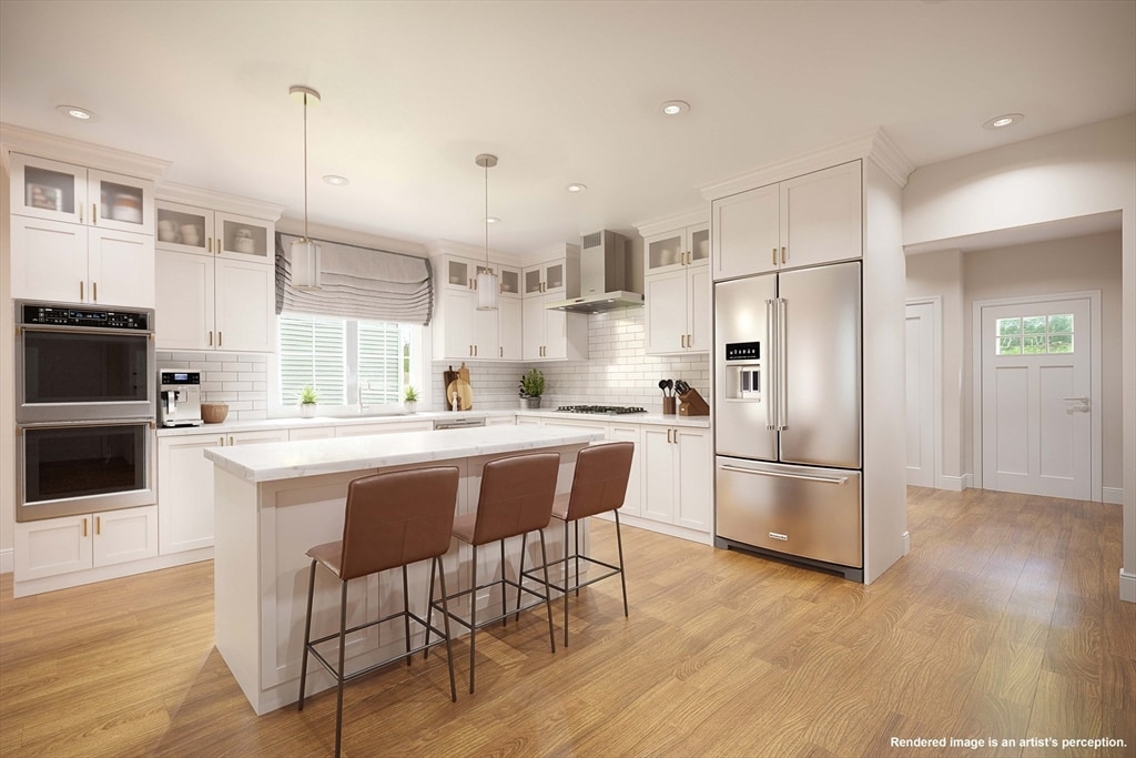 kitchen with light wood-type flooring, a center island, stainless steel appliances, and wall chimney range hood