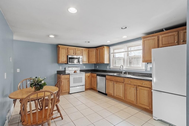 kitchen featuring dark countertops, recessed lighting, light tile patterned flooring, stainless steel appliances, and a sink