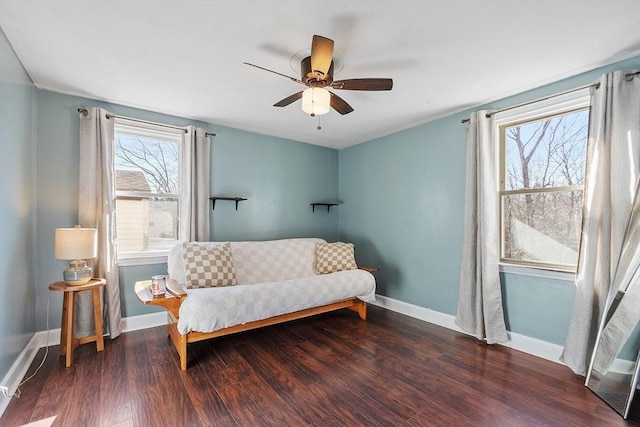 living area featuring ceiling fan, baseboards, and wood finished floors