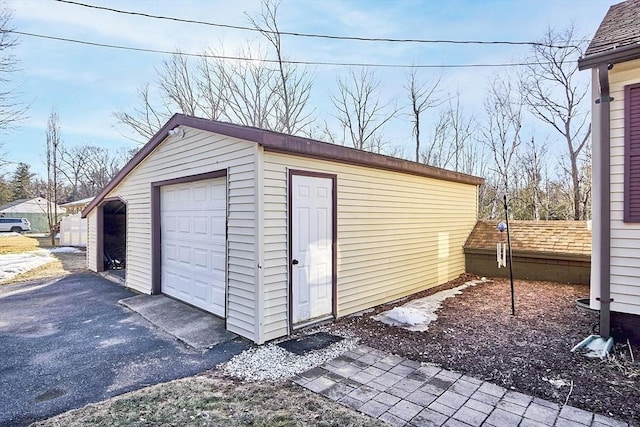 detached garage with fence and driveway