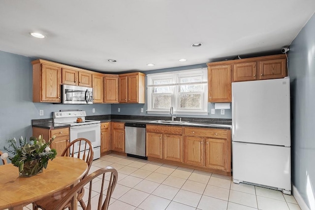 kitchen with light tile patterned flooring, recessed lighting, a sink, appliances with stainless steel finishes, and dark countertops