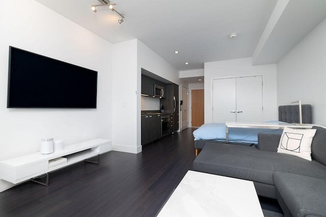 living room with dark wood finished floors, baseboards, and recessed lighting