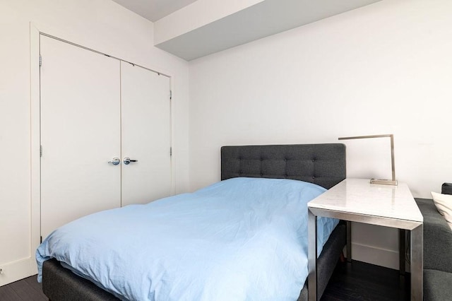 bedroom featuring dark wood-type flooring and a closet