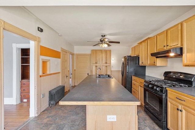128 7th St, Montague, MA 01376 - kitchen featuring black appliances, under cabinet range hood, a sink, radiator, and a kitchen island with sink