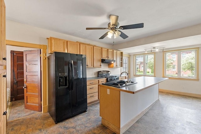 128 7th St, Montague, MA 01376 - kitchen featuring black fridge with ice dispenser, range with gas cooktop, under cabinet range hood, a sink, and light brown cabinets
