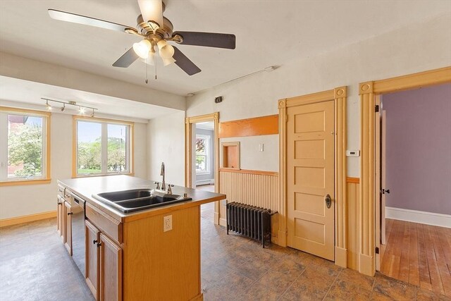 128 7th St, Montague, MA 01376 - kitchen featuring a sink, dishwasher, a center island with sink, a ceiling fan, and baseboards