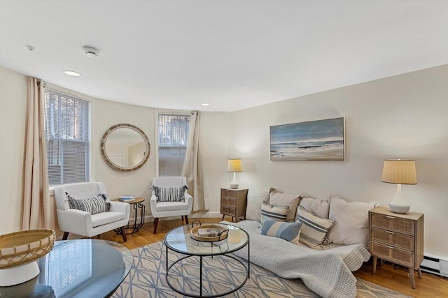 living room with baseboards, a baseboard heating unit, wood finished floors, and recessed lighting