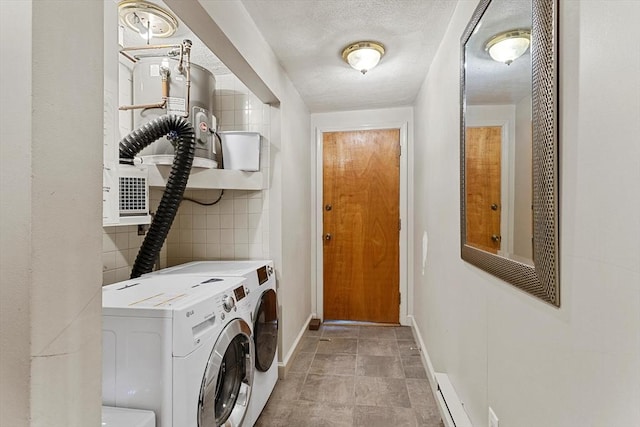 laundry area with a textured ceiling, laundry area, washer and clothes dryer, and baseboards