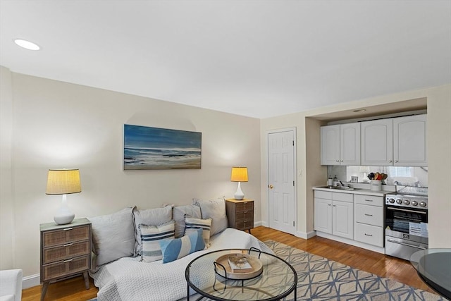 living area with light wood-type flooring and baseboards