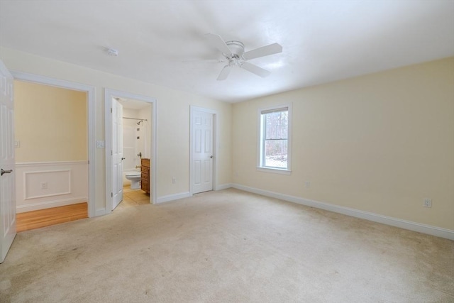 unfurnished bedroom featuring light colored carpet, connected bathroom, and ceiling fan