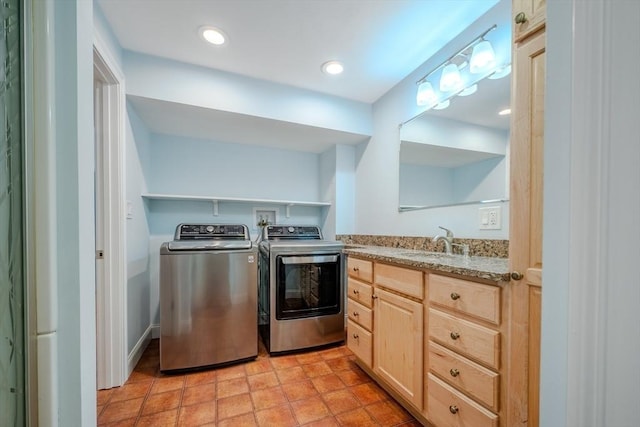 clothes washing area featuring recessed lighting, independent washer and dryer, and a sink