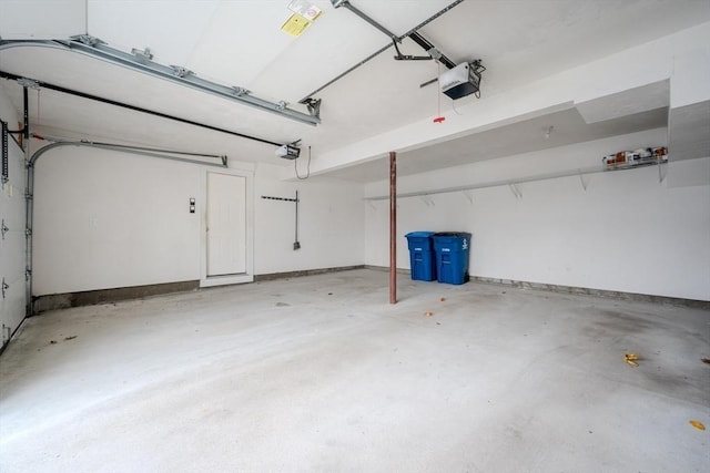 garage featuring a garage door opener and baseboards