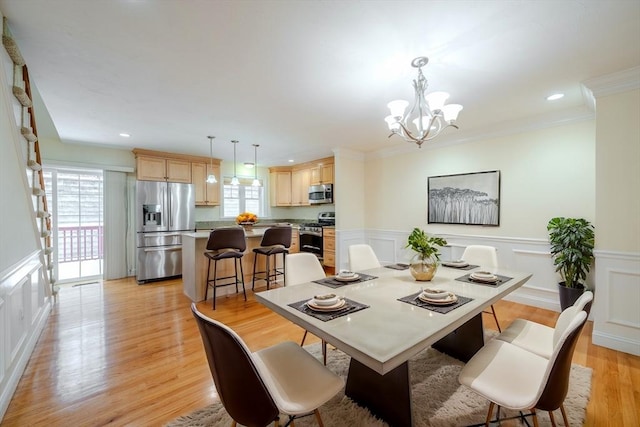 dining room with a healthy amount of sunlight, light wood finished floors, and ornamental molding