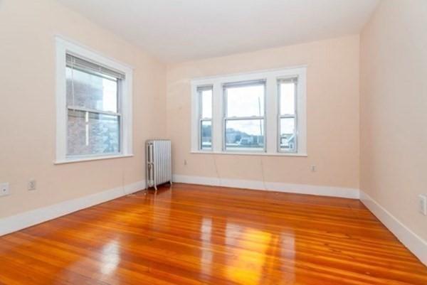 34 Channing St Unit C, Newton, MA 02458 - empty room with plenty of natural light, baseboards, radiator, and wood finished floors