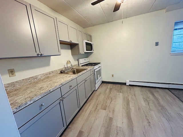 kitchen featuring ceiling fan, a textured ceiling, light wood-type flooring, sink, and white appliances